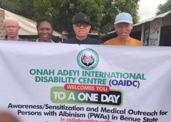 Persons with Albinism holding an event flex banner along with Mr Onah